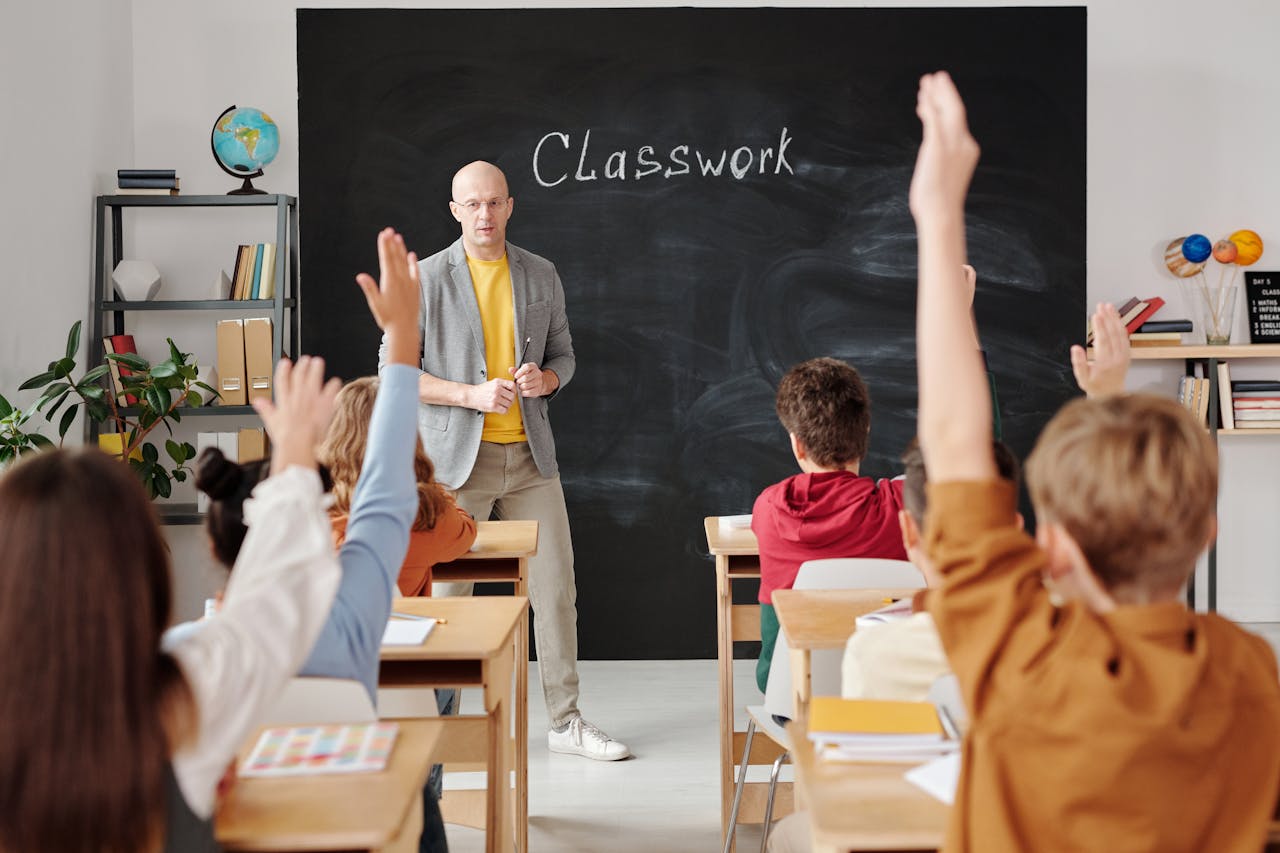 A teacher interacts with diverse students in a classroom, engaging them in active learning.